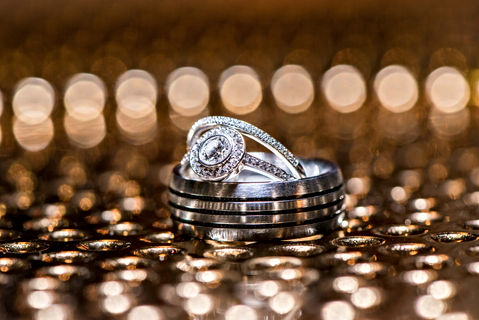 Close-up of wedding rings on a sparkling surface