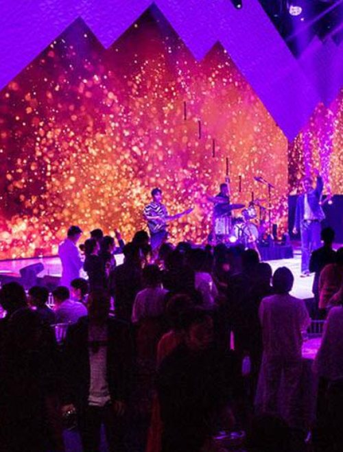 Stage with performers and a vibrant backdrop at an event