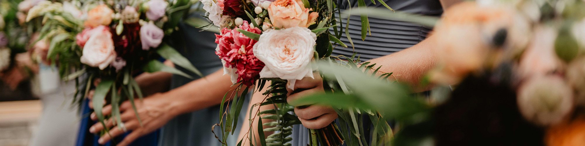 Bridal party holding colorful floral bouquets