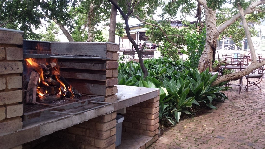 Braai area with fire and seating among greenery