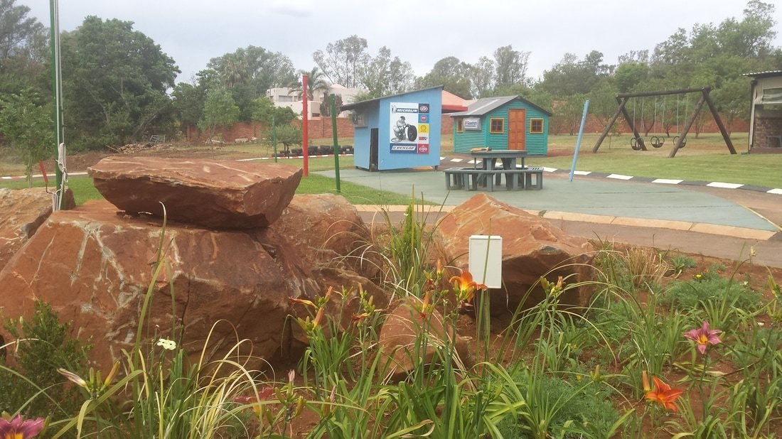 Children's play area with swings and playhouse.