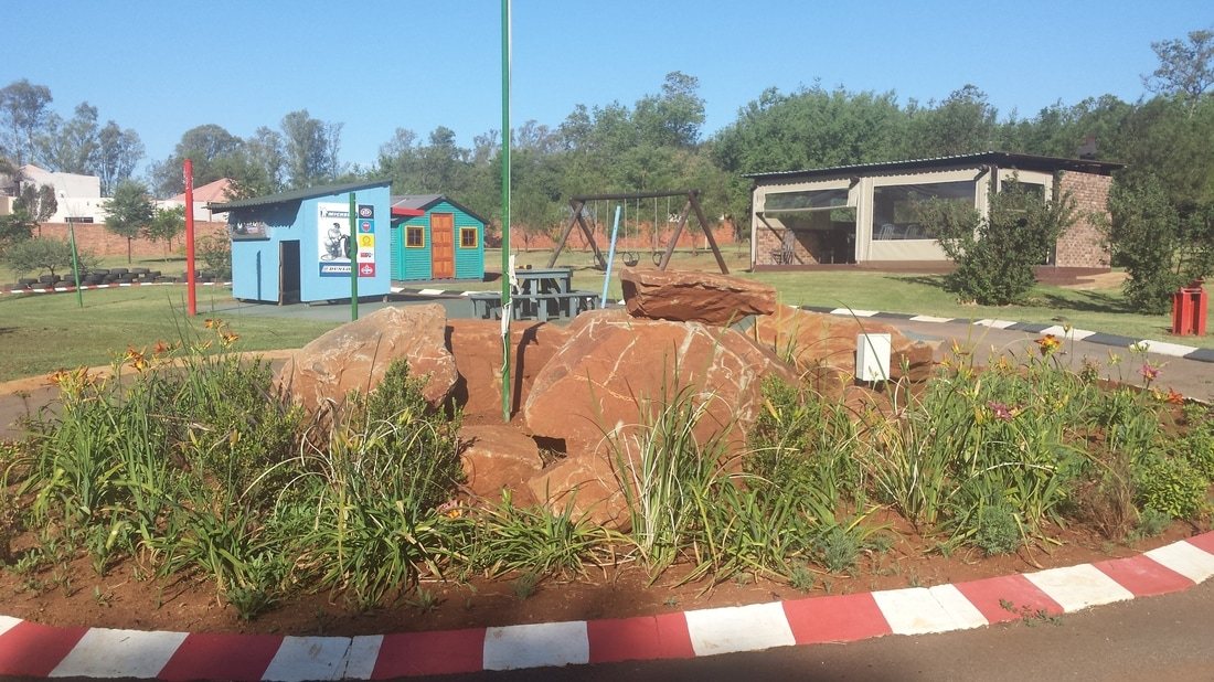 Children's play area with rocks, flowers, and play equipment