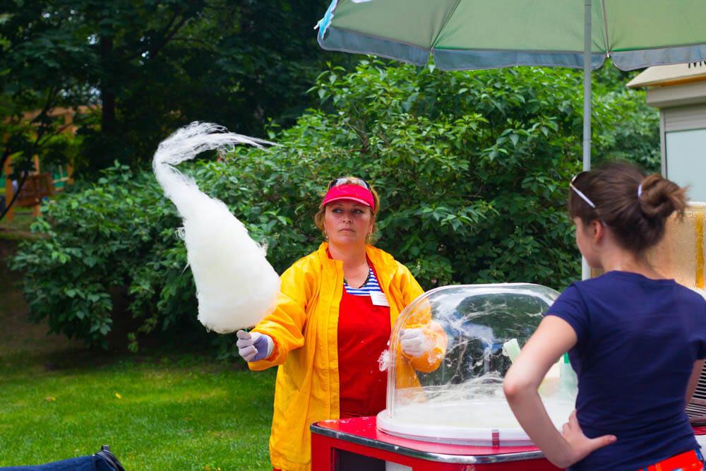 Candy floss machine with operator preparing cotton candy