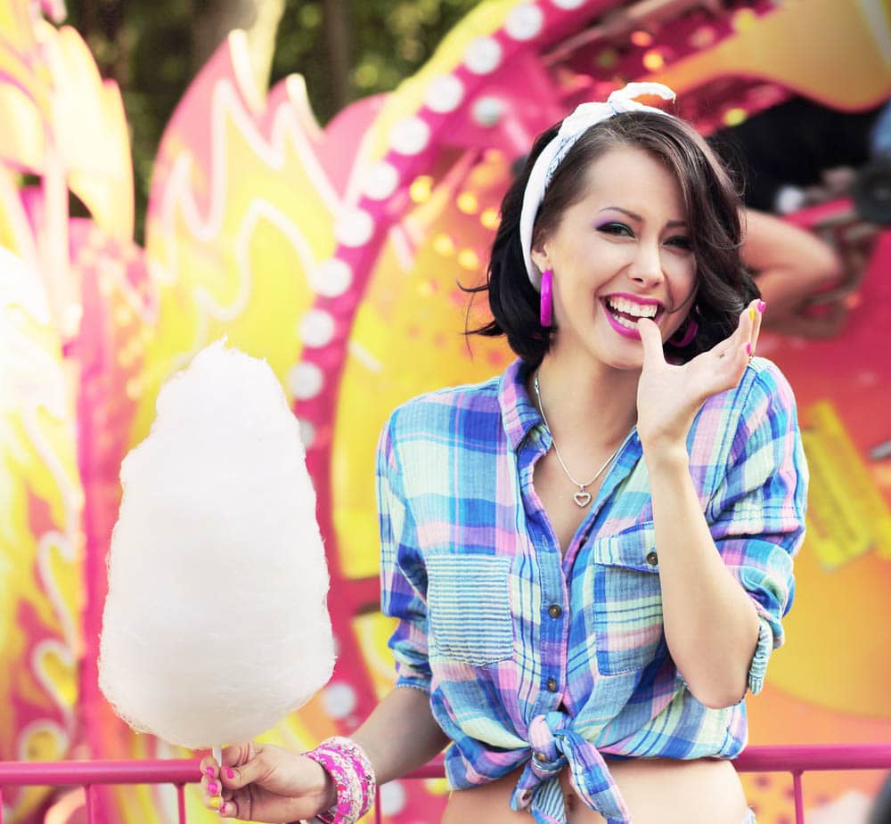 Person enjoying a large cotton candy at an event