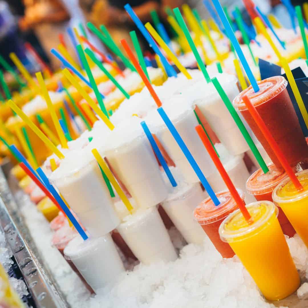 Colorful slushy drinks with straws on ice