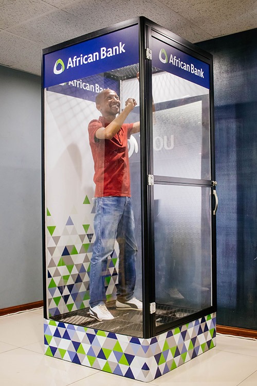 A person inside an interactive money booth at a corporate event.