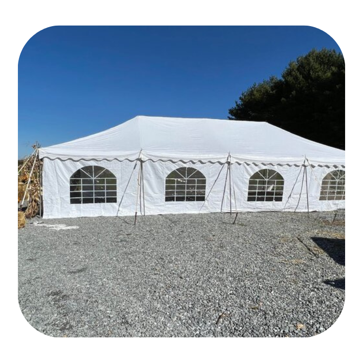 Large white frame tent with windows on gravel surface