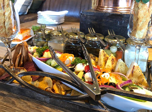 A gourmet snack platter with vegetables, cheeses, and dips.