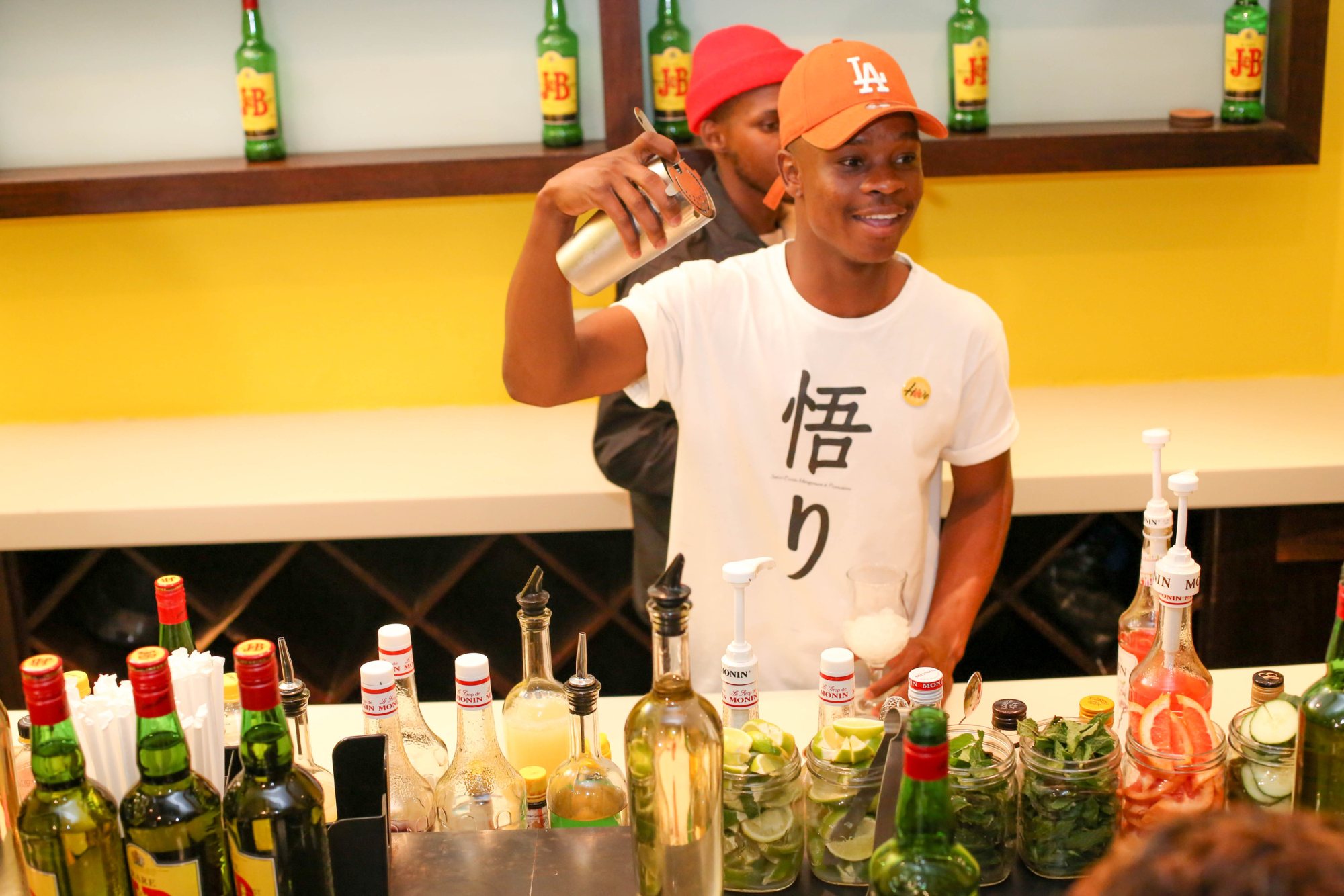 Bartender shaking a cocktail at a vibrant mobile bar.