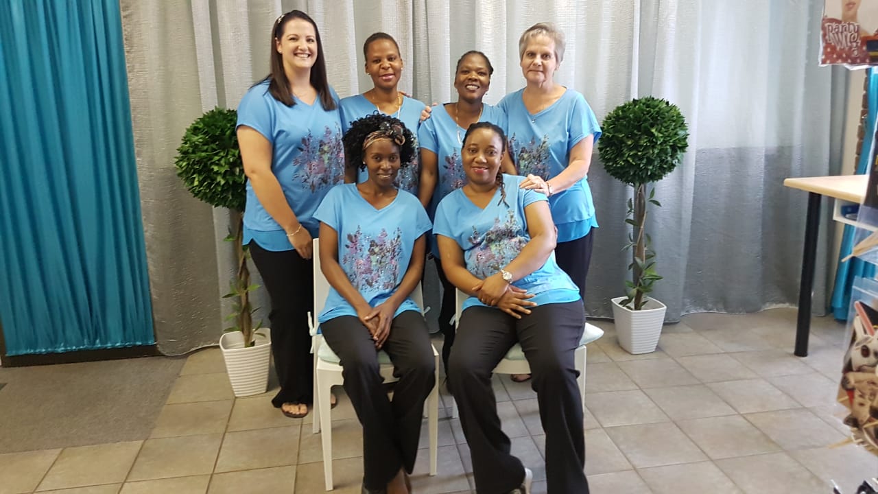 Group of six staff members in blue uniforms
