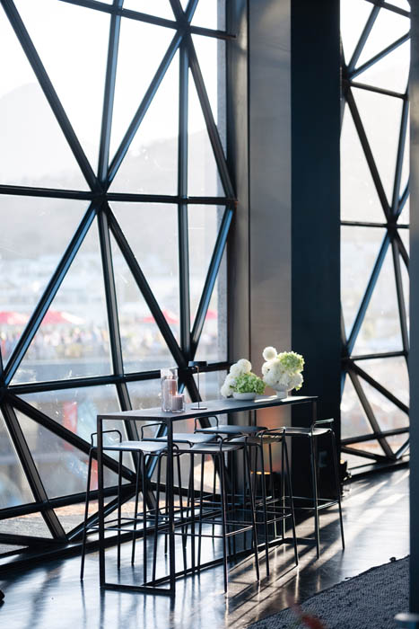Minimalist table setup near large geometric windows