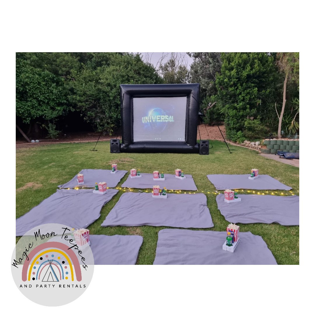 Outdoor movie setup with inflatable screen and blankets
