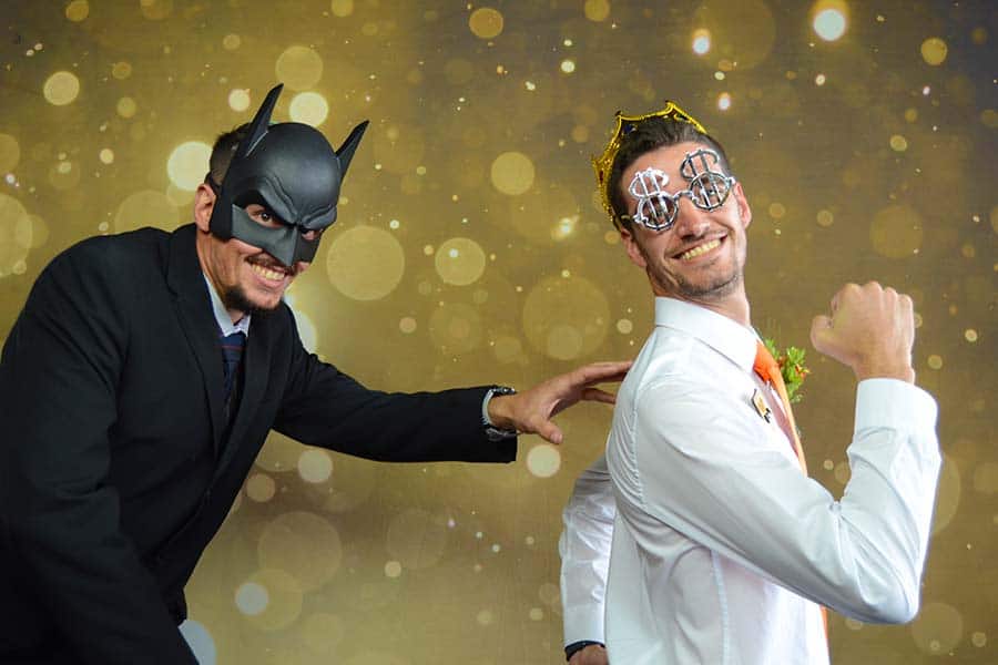 Two men in costume props posing for a photo booth picture.