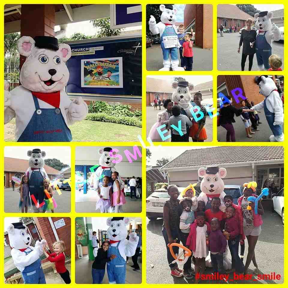 Children interacting with a bear mascot at an event.