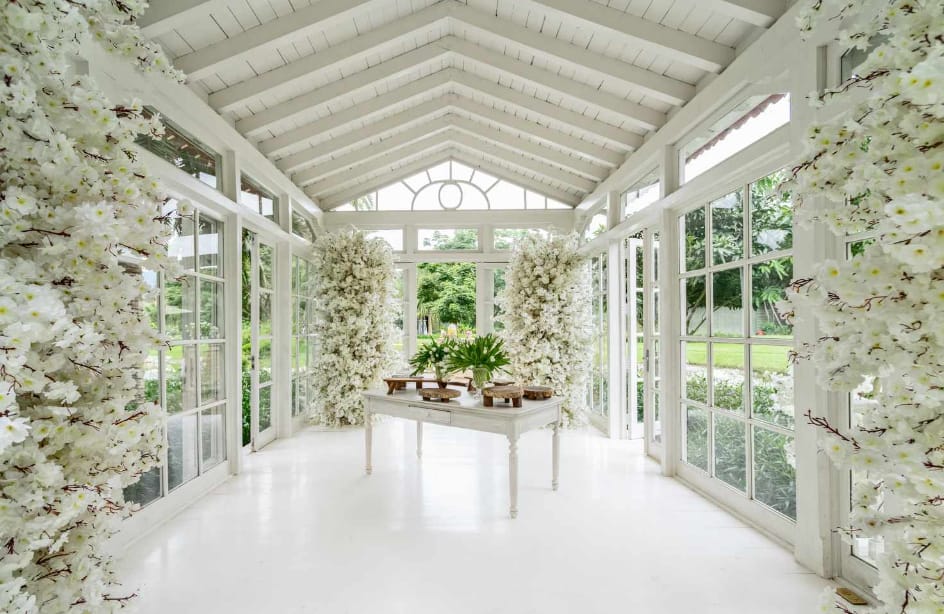 Bright white room with floral decorations and large windows