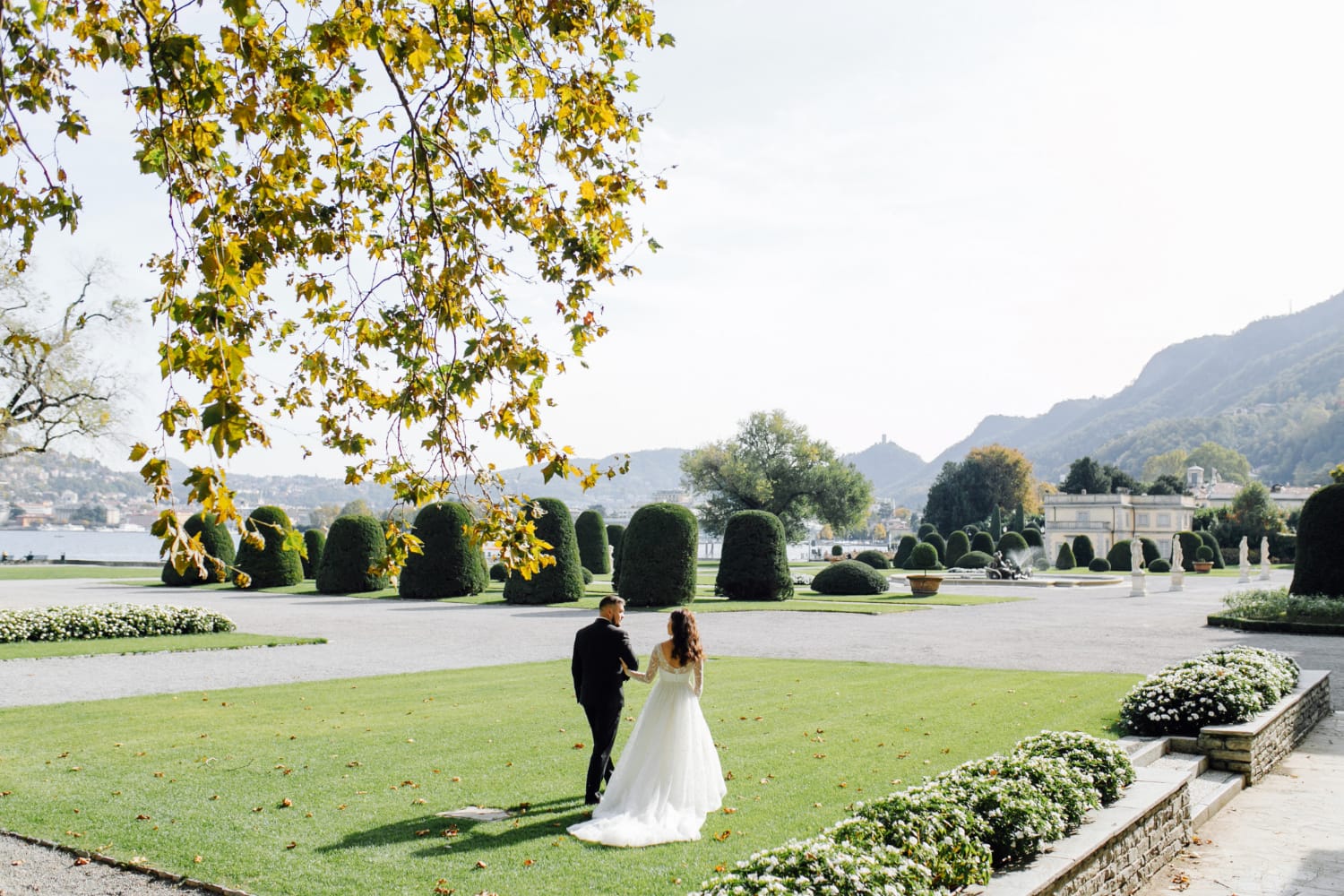 A couple walking in a beautifully landscaped garden.