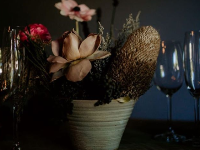 Floral arrangement in a ceramic pot with glasses