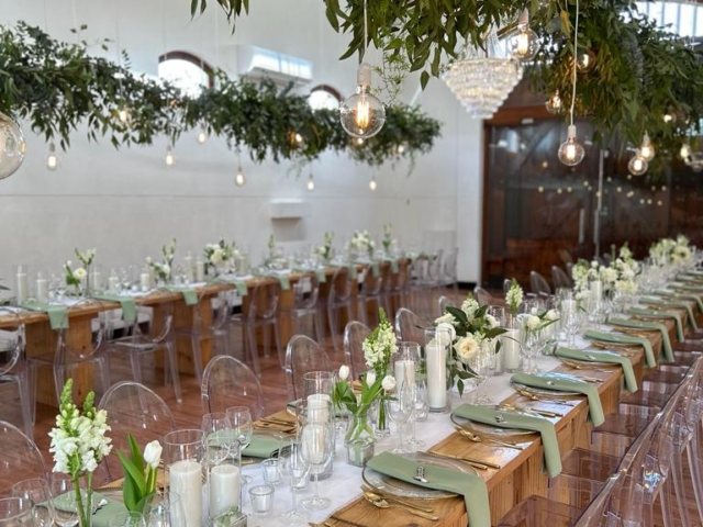 Long table with floral arrangement and greenery decor in venue