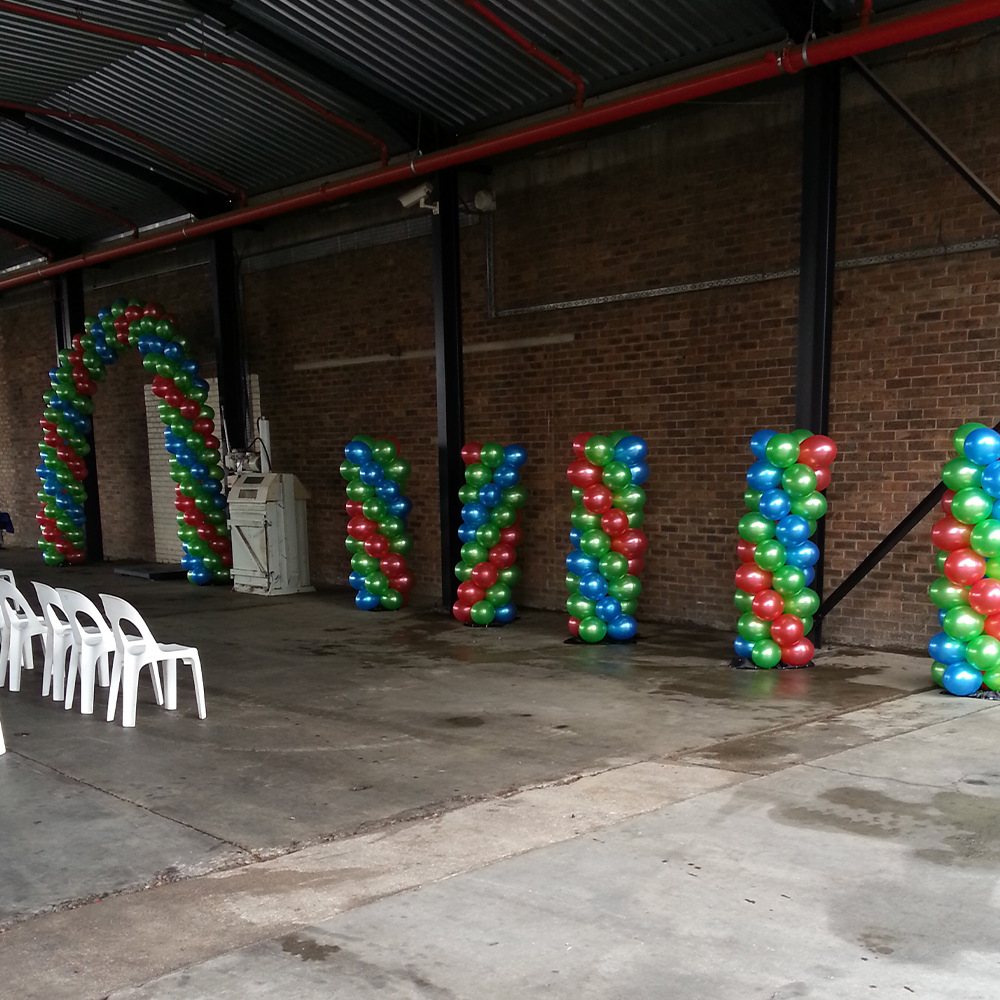 Colorful balloon columns and arch in an event space.