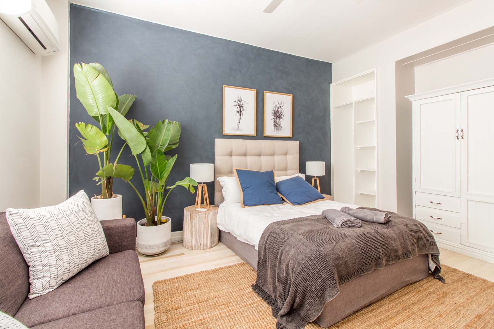 Cozy room with bed, couch, and decorative plants