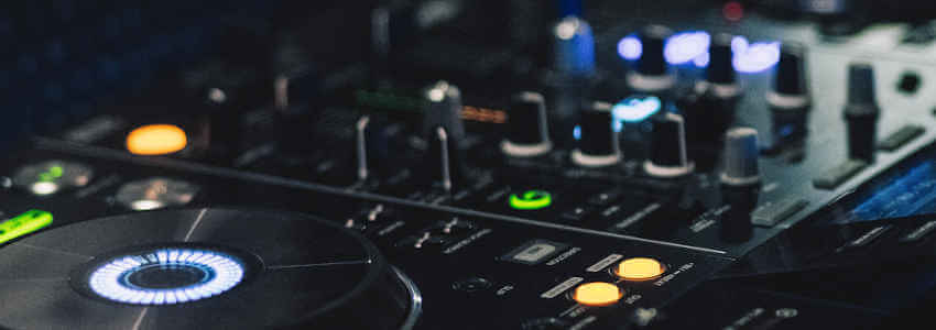 Close-up of a professional DJ controller with colorful lights and knobs