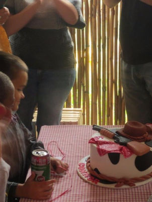 A decorated cake with a cowboy theme on a table