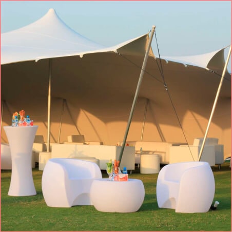 Outdoor lounge area with seating and refreshments under a stretch tent.