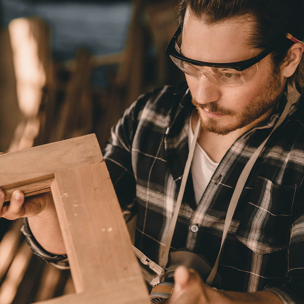 Artisan measuring a wooden frame in a workshop