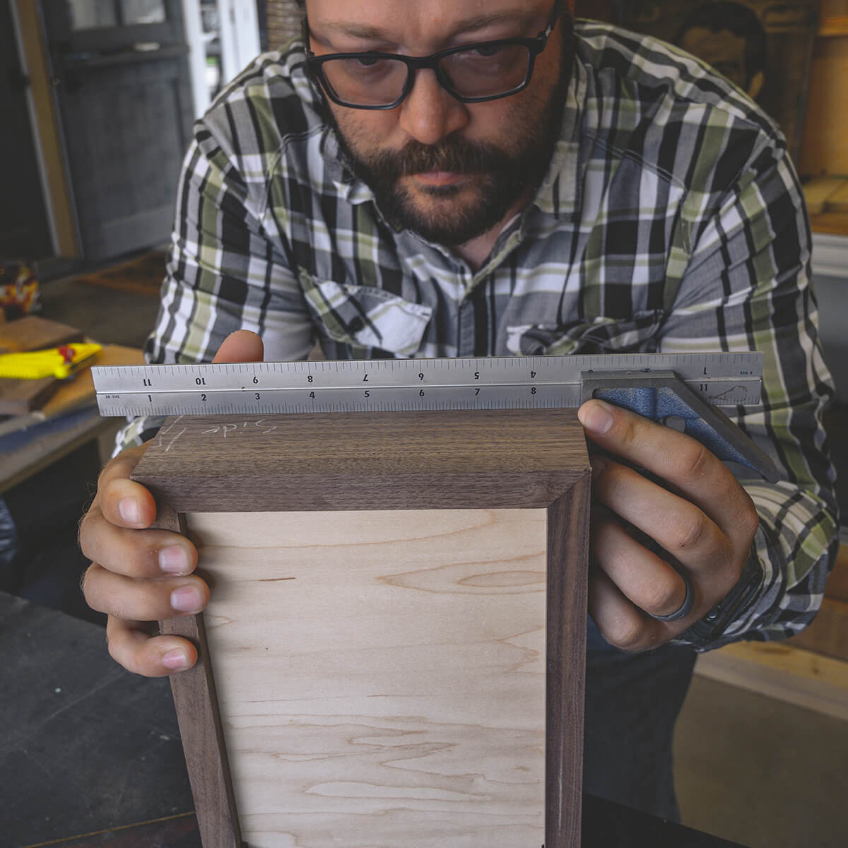 A craftsman measuring wood with a ruler