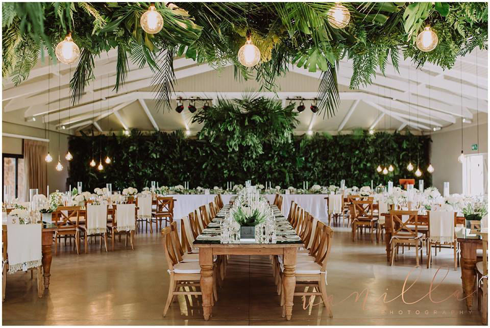 Event venue with greenery decor and long dining tables