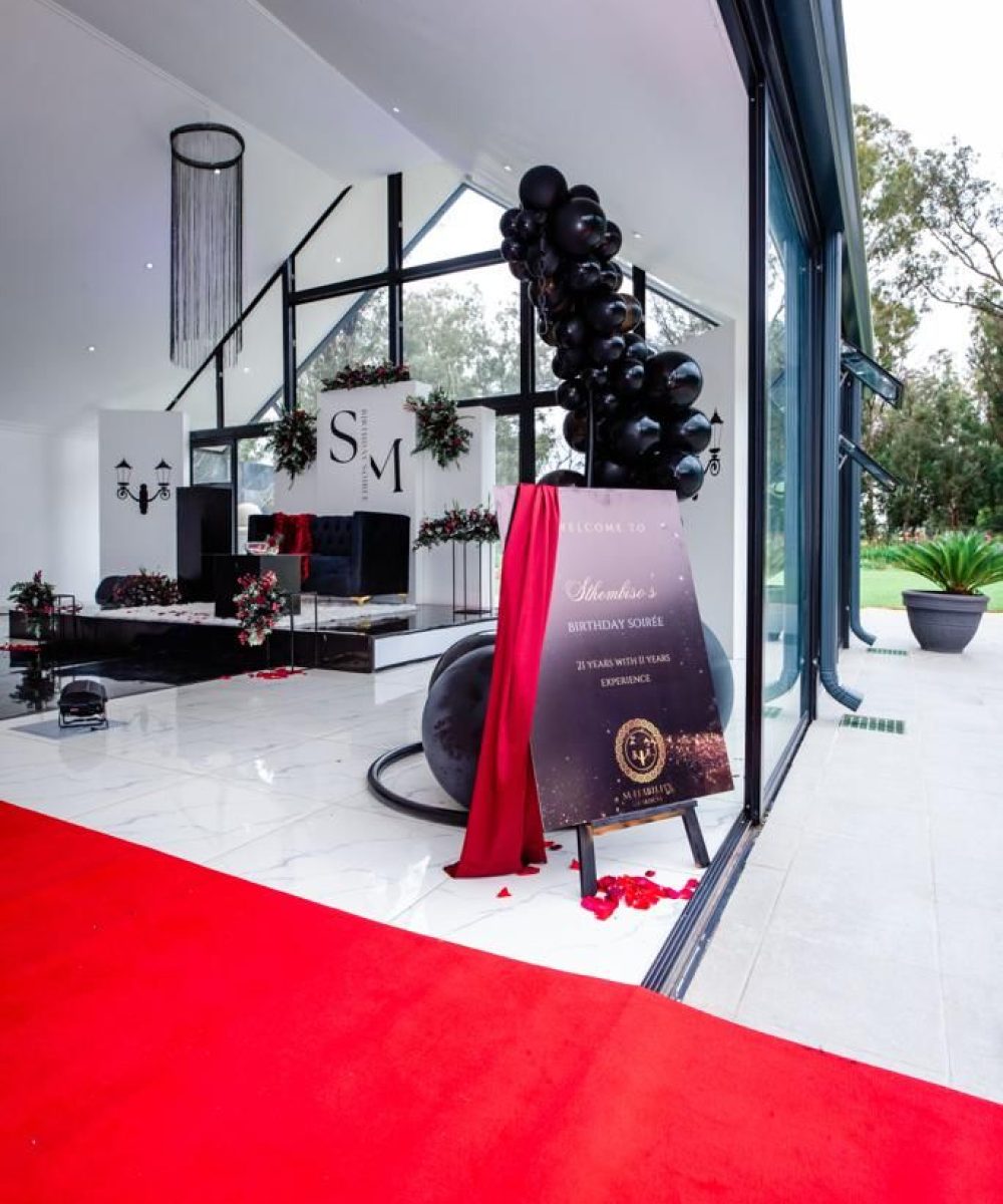 Red carpet entrance with welcome sign for a birthday event
