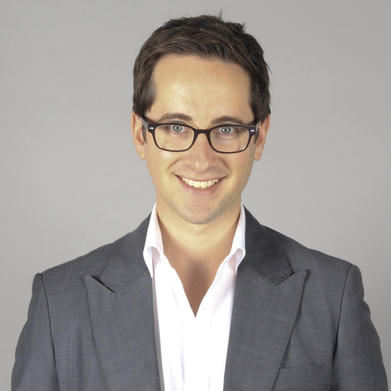 Smiling man in grey suit and glasses