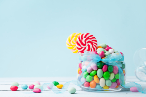Glass jar filled with colorful candies and lollipops