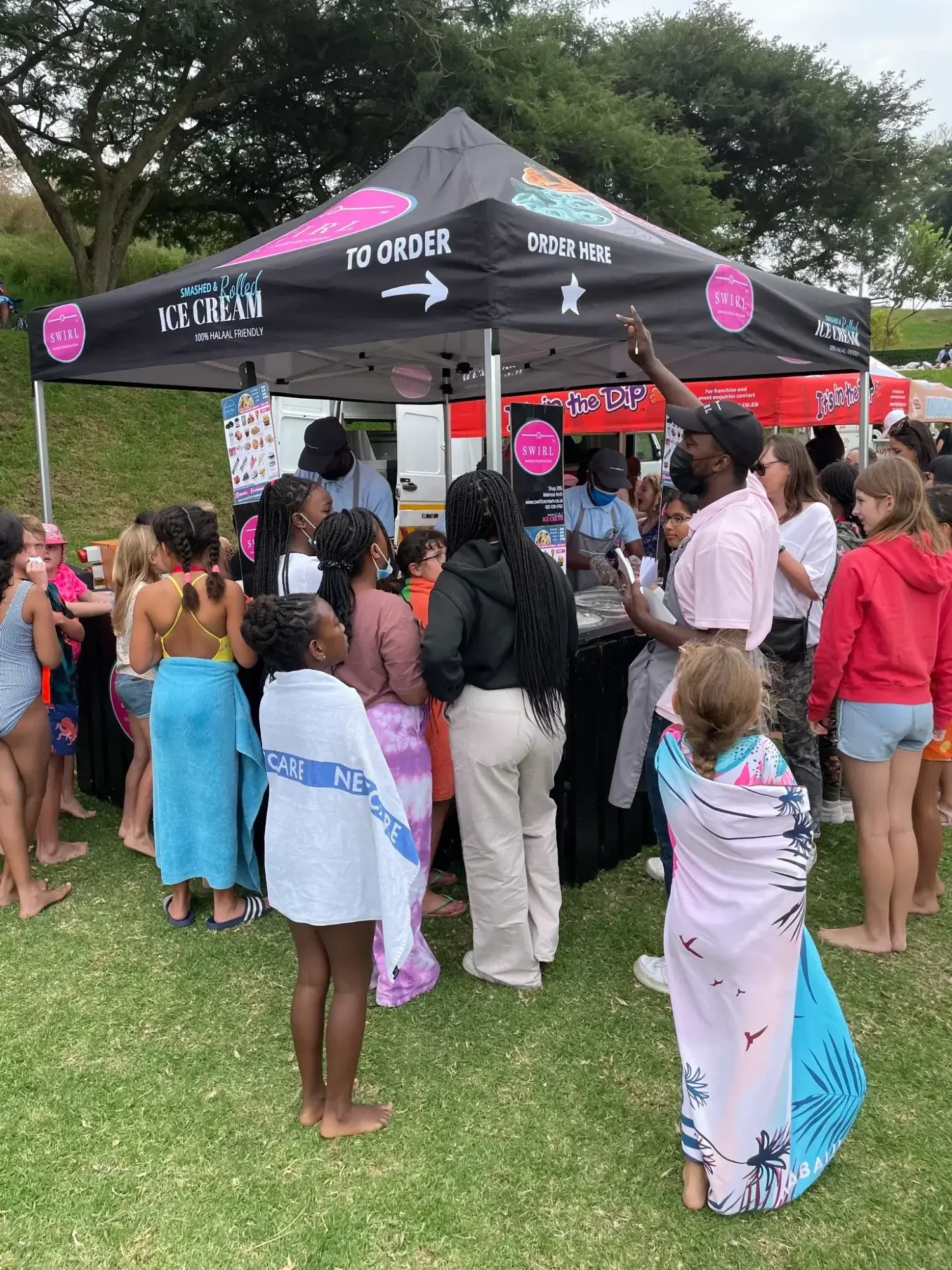 Swirl Ice Cream stand with children and adults ordering ice cream.