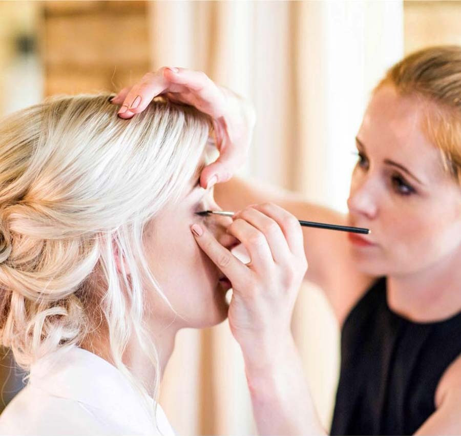 Makeup artist applying eyeliner on a bride