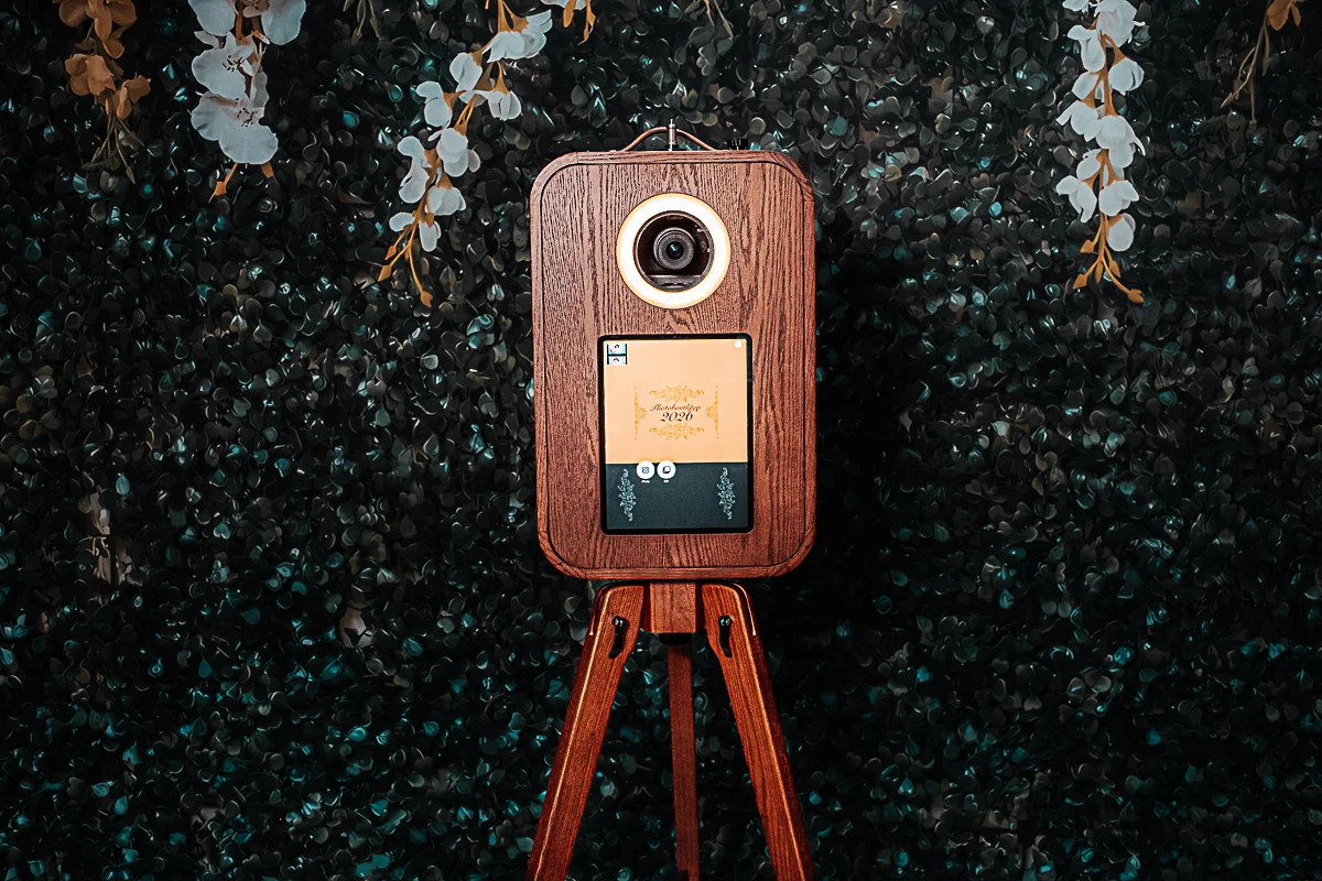 A vintage camera booth on a wooden tripod.