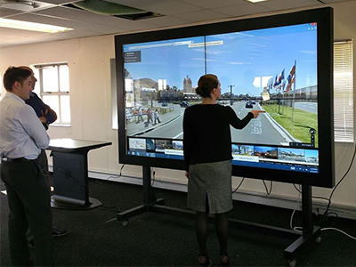 A large interactive touch screen being used by two people.