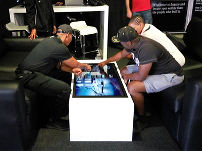 Three people interacting with a touch screen table