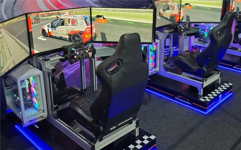 Two racing simulator stations with screens and steering wheels.