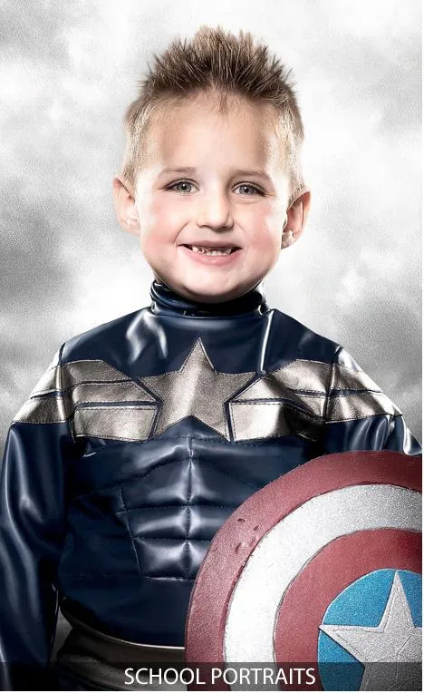 Child in superhero costume holding a shield for school portrait.