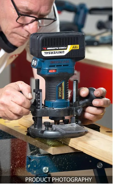 Close-up of a man using a router on wood