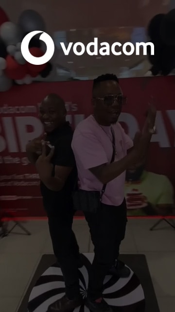 Two men posing on a 360-degree photo booth platform.