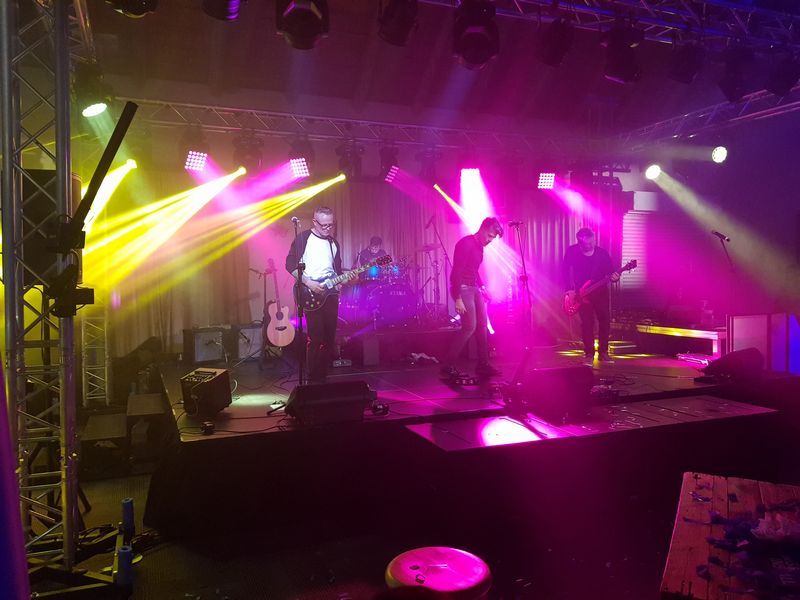 Band performing on stage with colorful lighting effects
