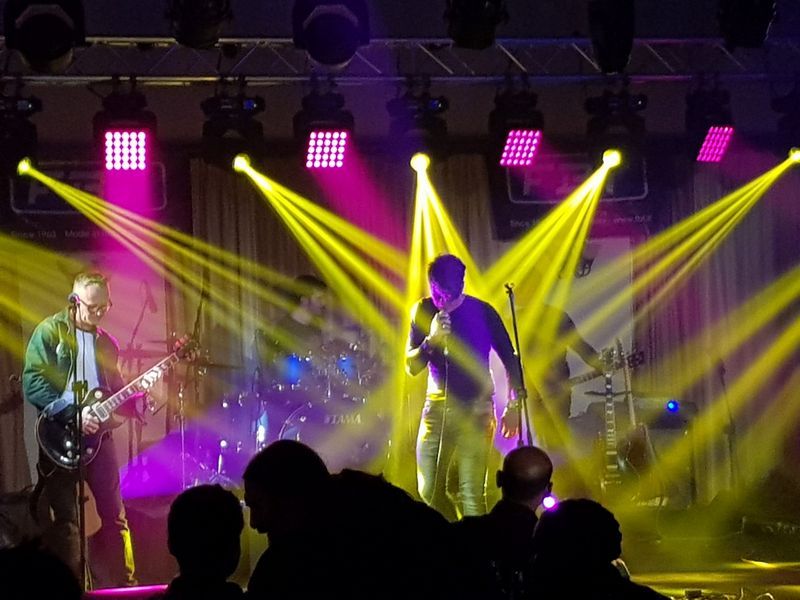 Musicians performing on stage with colorful lighting