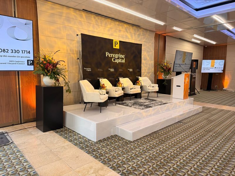 Corporate event staging setup with chairs and floral decor