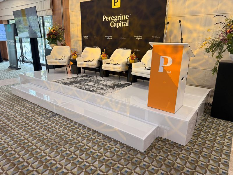 White corporate stage with podium and seating arrangement