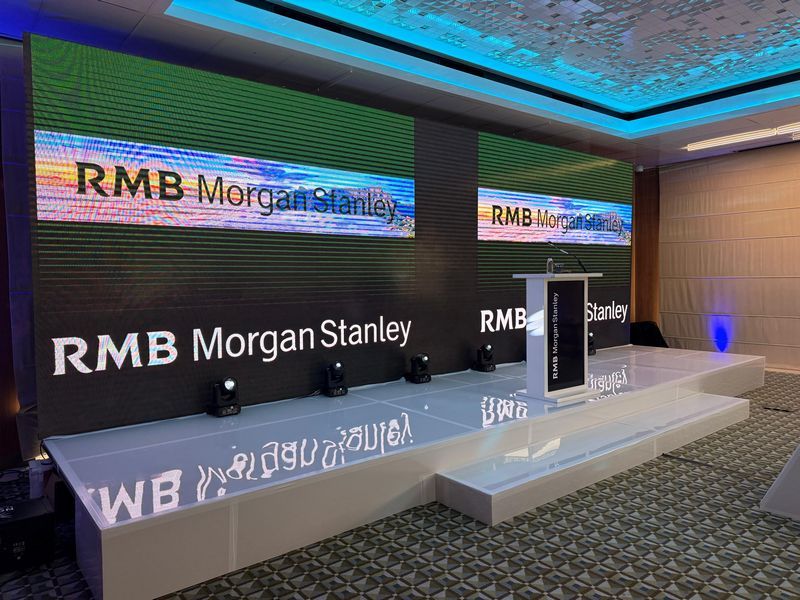 Stage setup for a corporate presentation with screens and podium