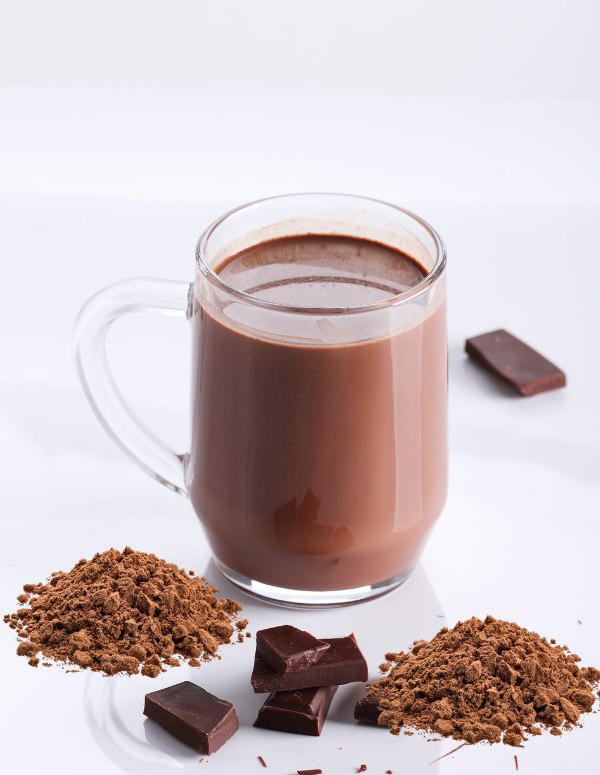 Glass of hot chocolate with chocolate pieces and cocoa powder