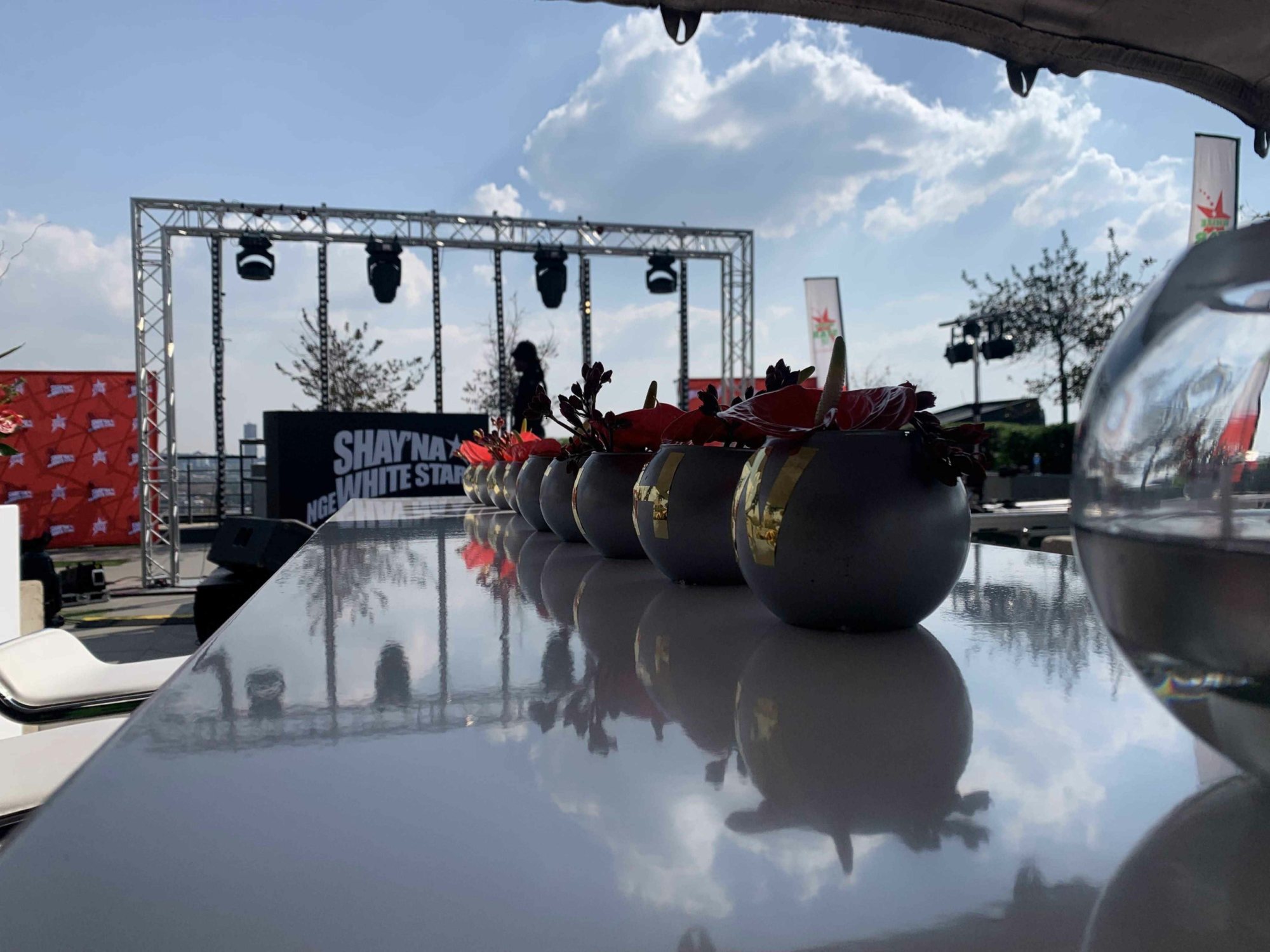 Rooftop bar with floral arrangements and event stage in view