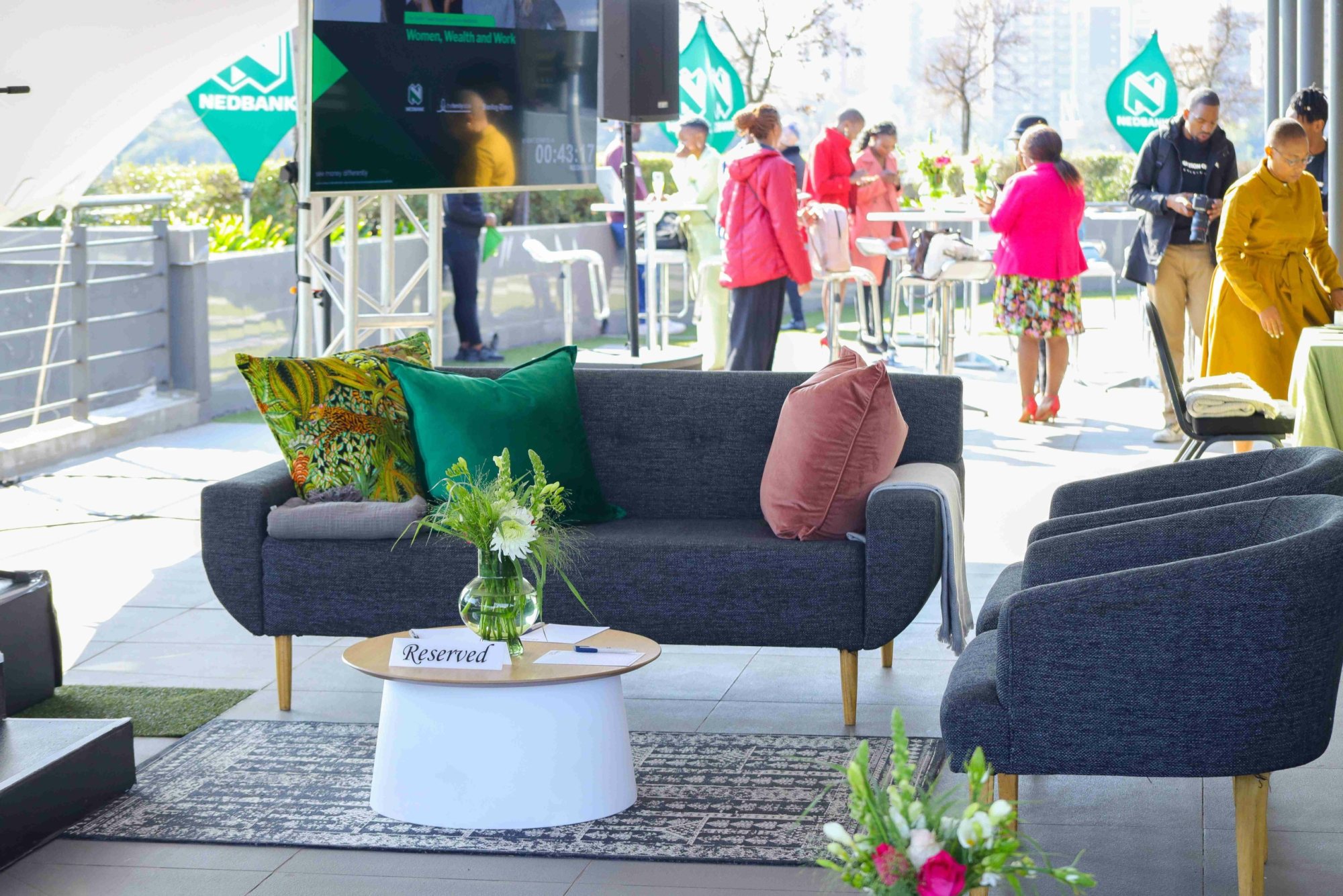 Comfortable lounge setup with reserved seating and floral arrangements on a rooftop